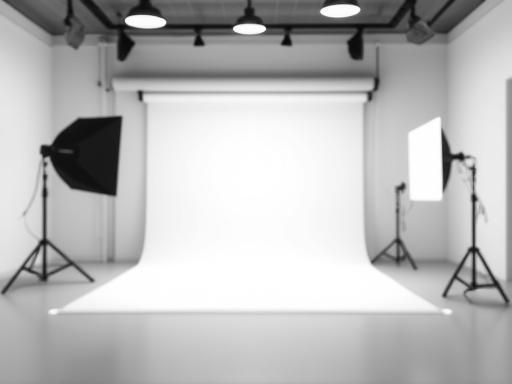 Empty photo studio with professional lighting setup and white backdrop
